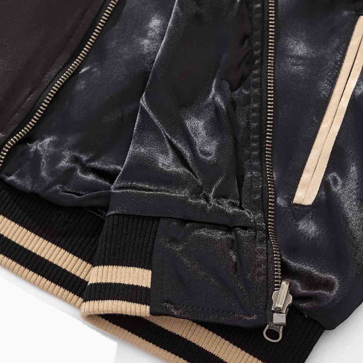 Hem detail — zipper guard and rib hem with contrast stripes.