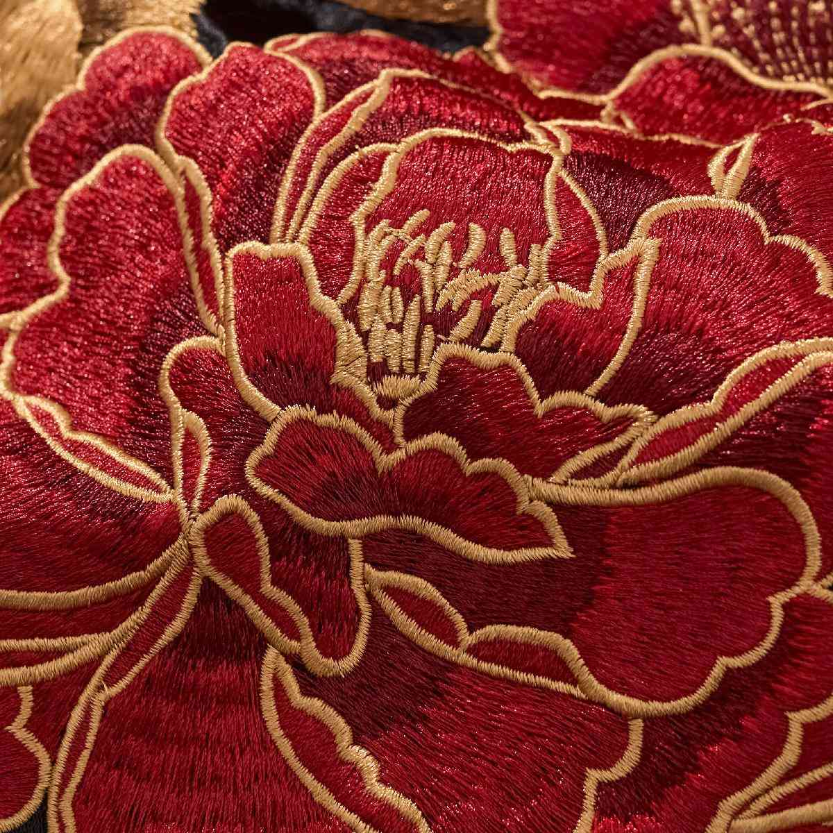 Macro embroidery — layered peony petals with golden outlines.