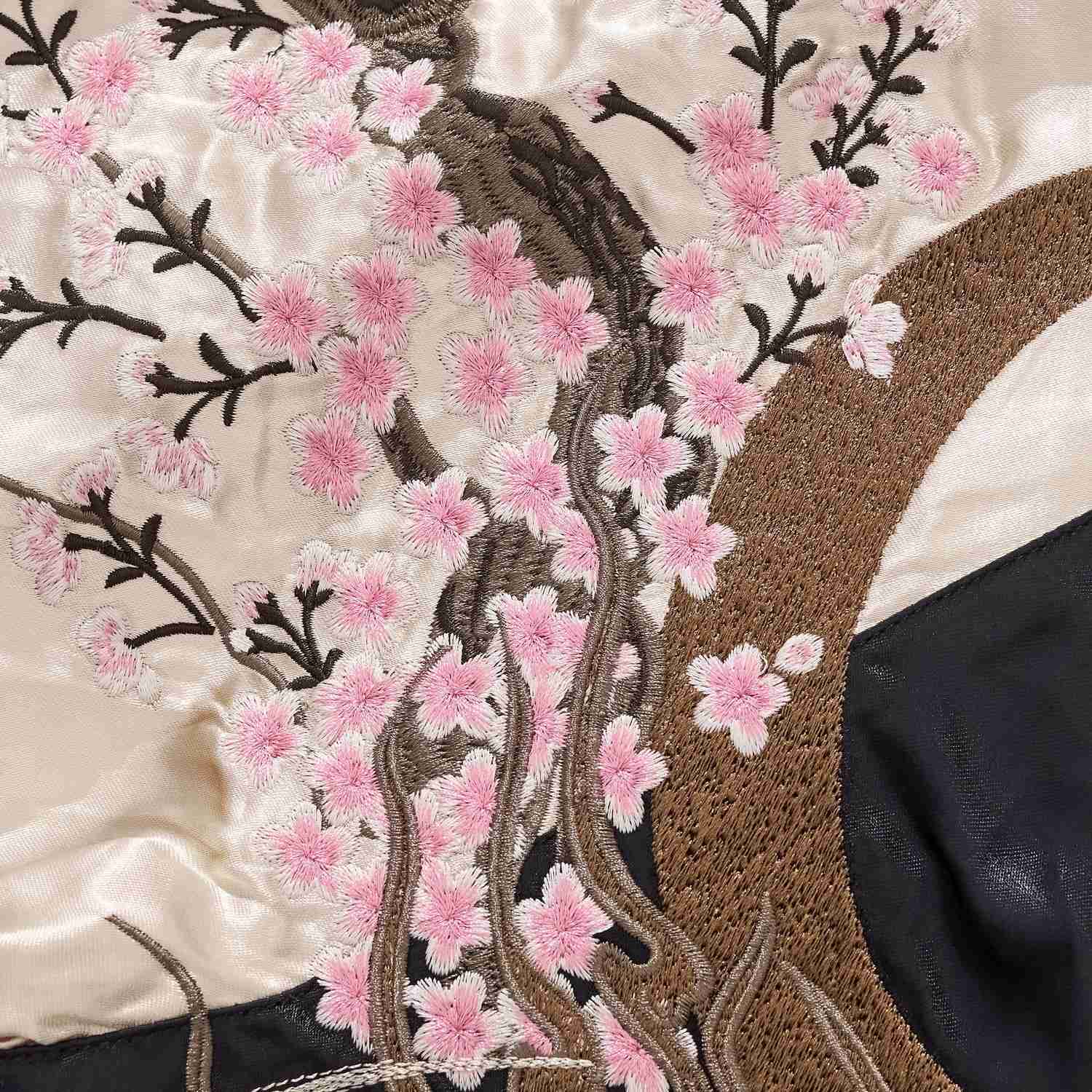 Soft pink sakura blooms beside the textured crescent.