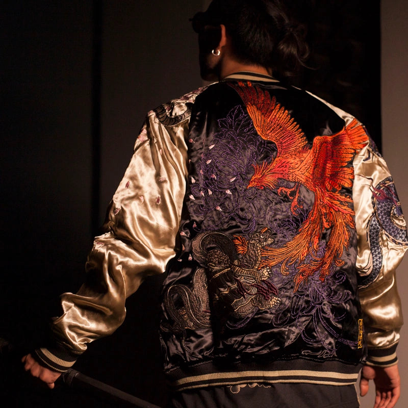 On-body back view — beige sleeves; large vermilion phoenix across the back with layered embroidery, floral and scale details.