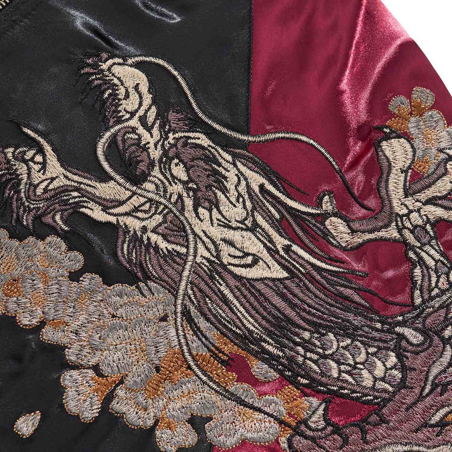 Dragon head embroidery detail with whiskers and teeth.