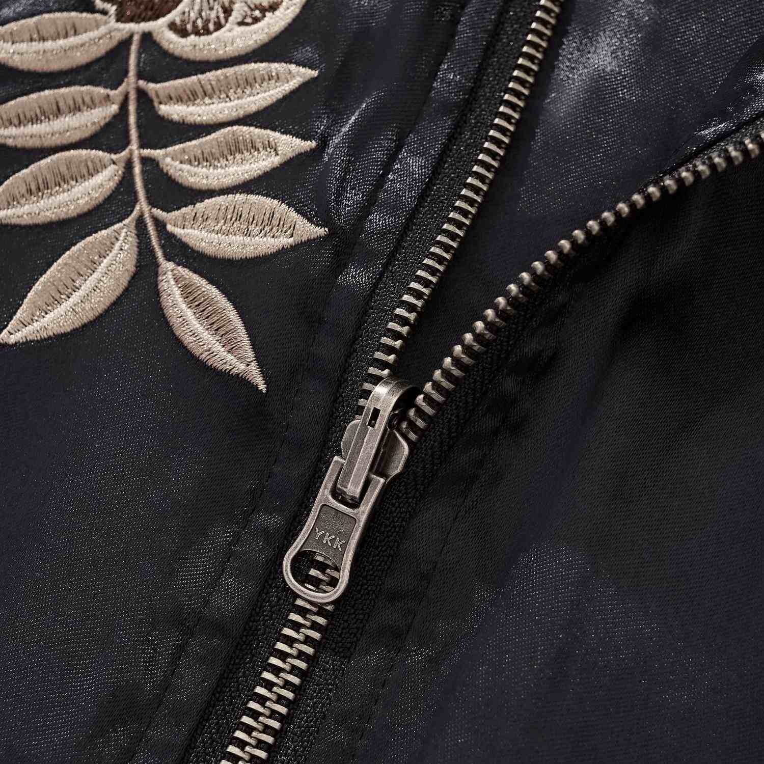 YKK zipper close-up with leaf embroidery.