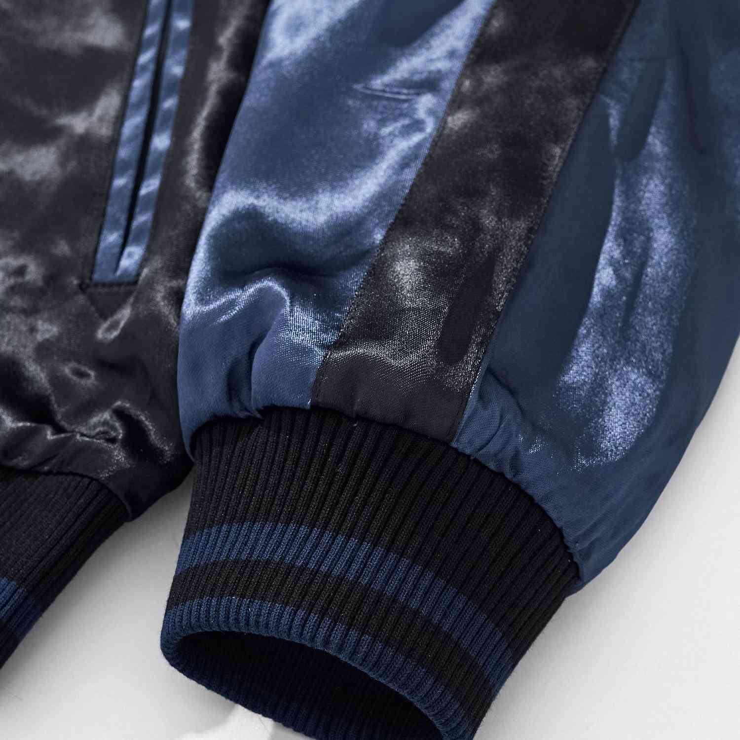 Ribbed cuff with contrast stripe and satin sleeve detail.