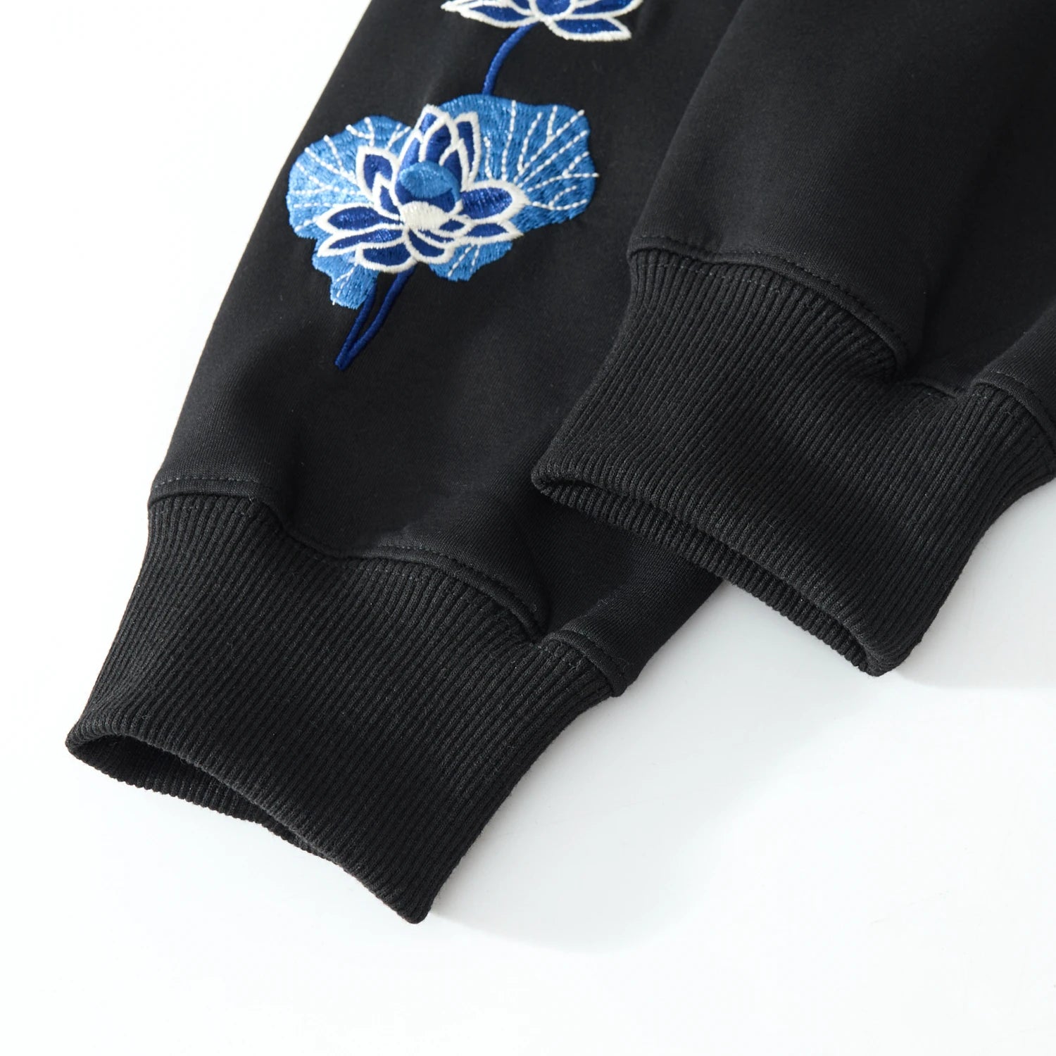 Ribbed cuffs close-up of the black Blue Phoenix & Lotus Embroidered Hoodie with lotus sleeve embroidery