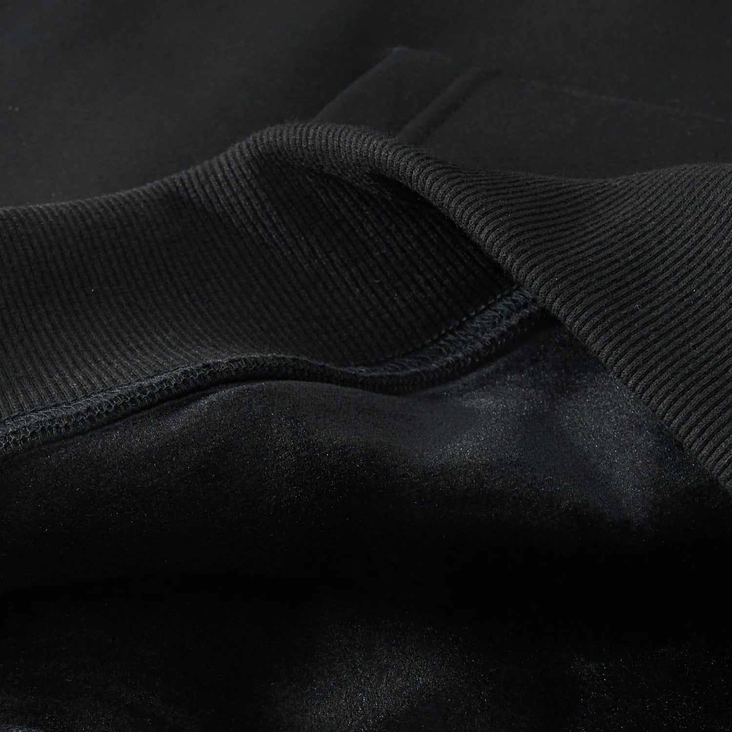 Hem and fleece lining close-up of the black Blue Phoenix & Lotus Embroidered Hoodie showing rib knit and soft brushed interior
