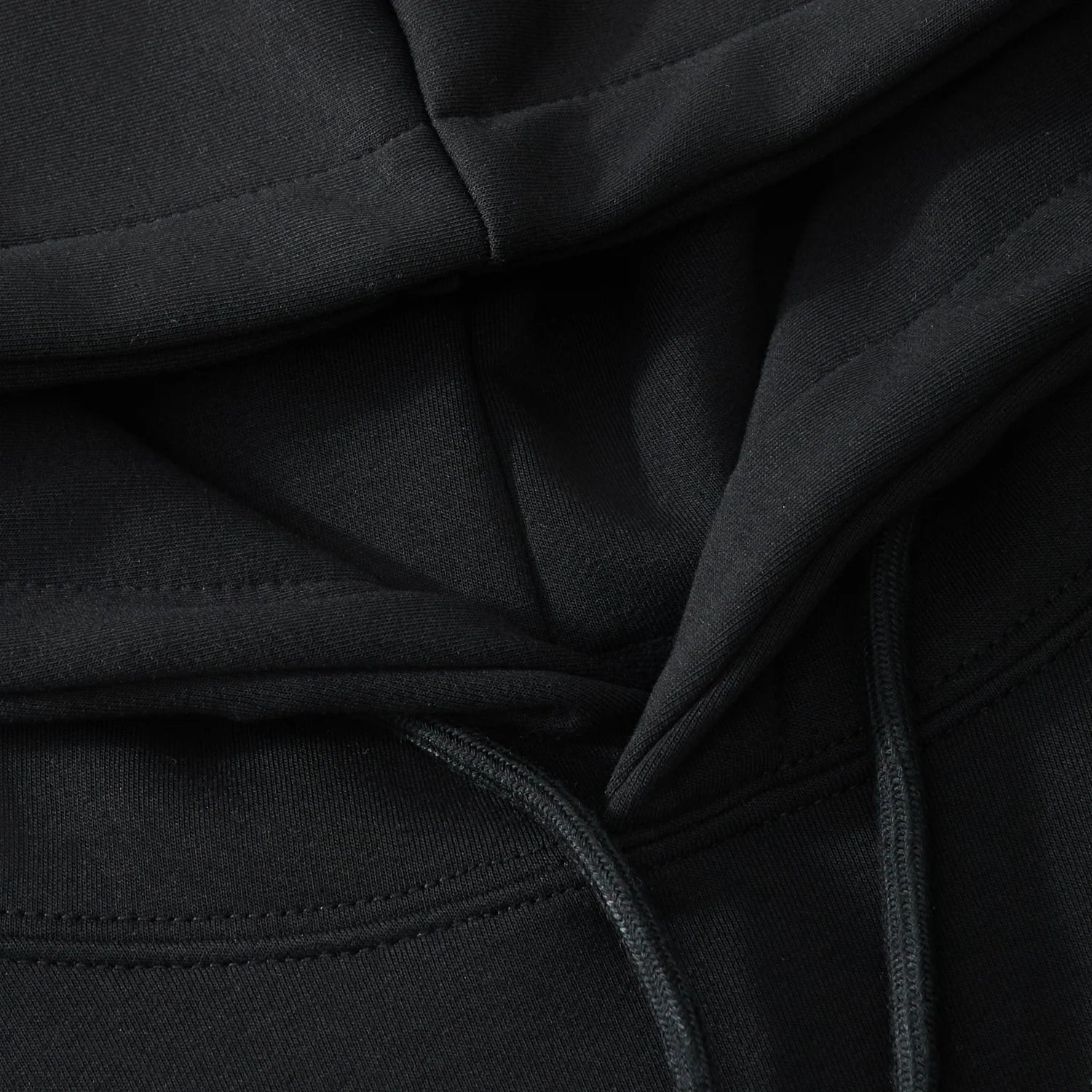 Hood lining and drawcord detail on the black hoodie with neat stitching