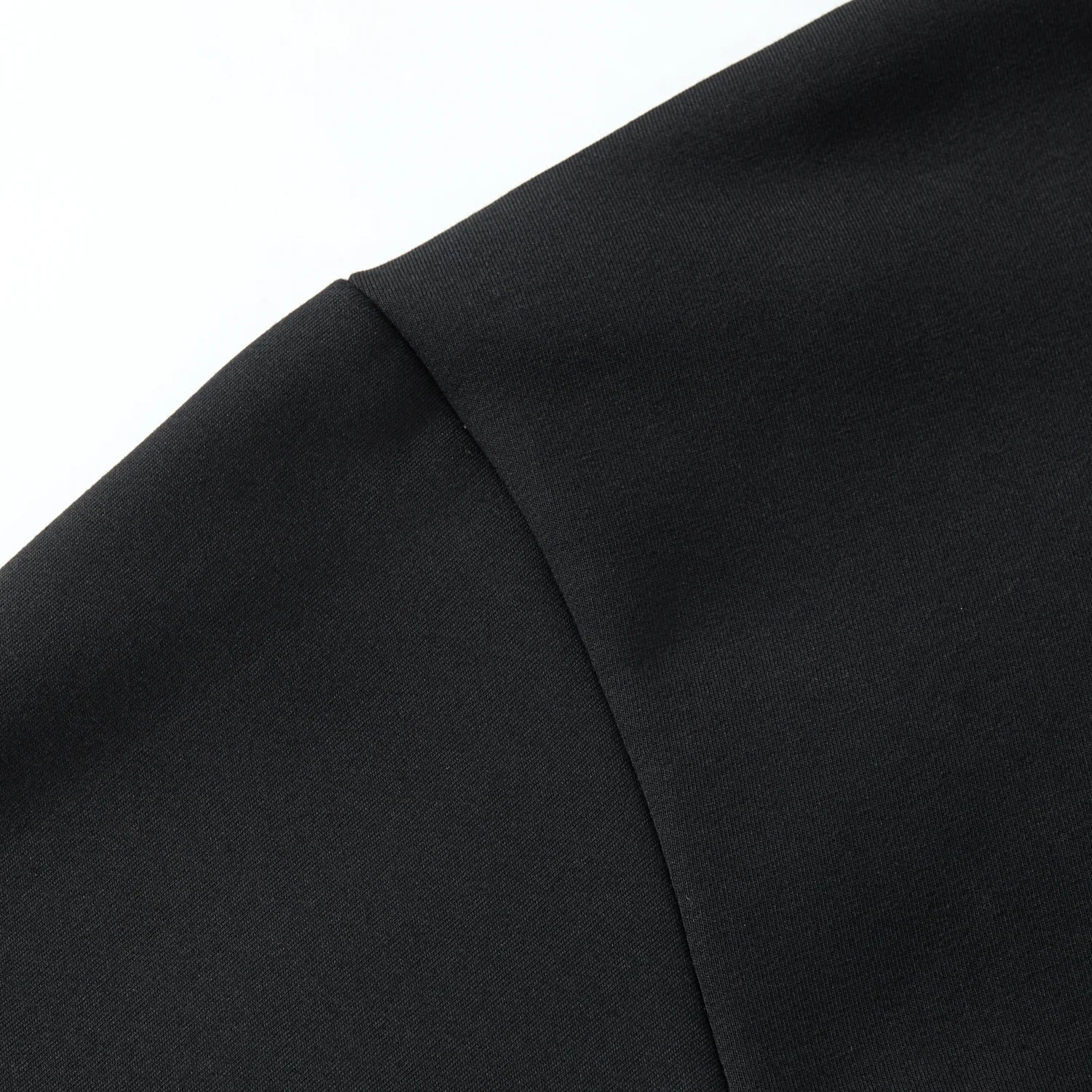 Shoulder seam detail on the black hoodie with smooth fabric and tidy seams