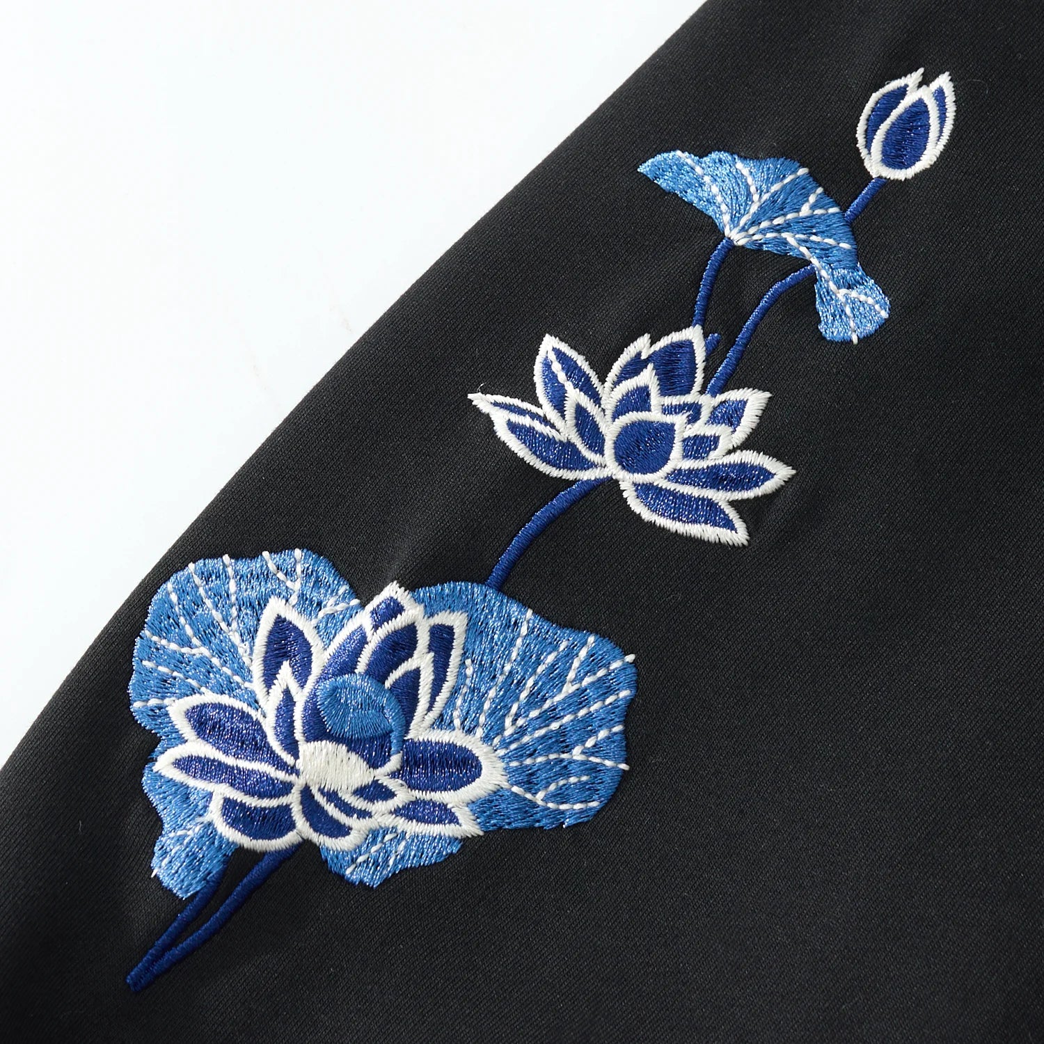 Lotus flower sleeve embroidery on the black hoodie with crisp satin stitches