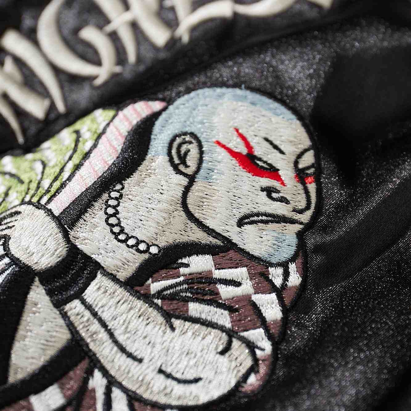 Close-up of bald fighter’s face and shoulder embroidery on back of Crows Suzuran vs Housen sukajan jacket.