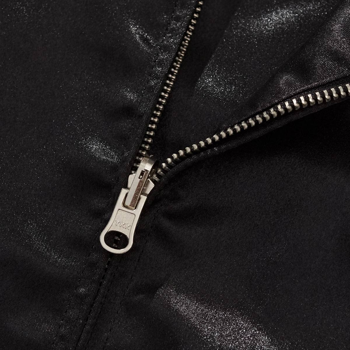Close-up of sturdy YKK front zipper on shiny black satin Dragon Ball Goku & Shenron sukajan bomber jacket.