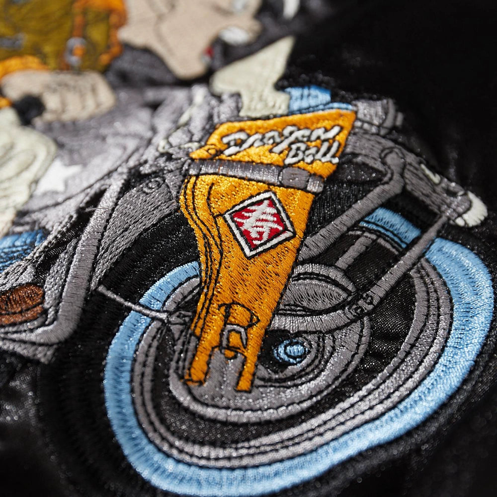 Macro detail of motorbike front fork and wheel embroidery with Dragon Ball logo on Dragon Ball Rider sukajan jacket.