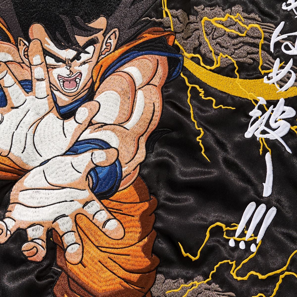 Macro embroidery detail of Goku charging a Kamehameha with lightning background on Dragon Balls sukajan jacket.