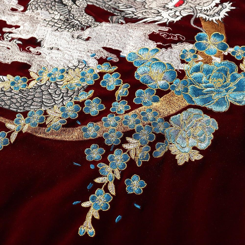Floral bouquet and branch embroidery beneath the dragon with crisp outlines and smooth gradients