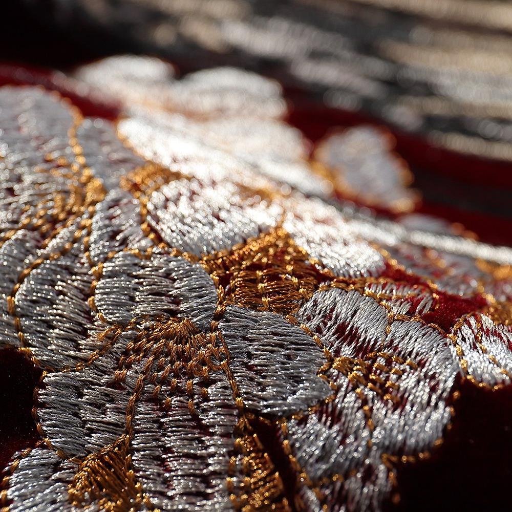 Close-up of sakura petal embroidery on the velvet sukajan showing dense satin stitches and metallic highlights