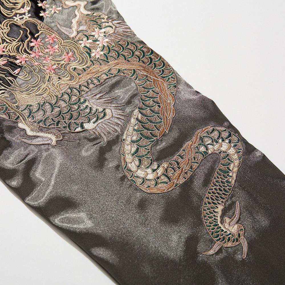 Close-up of dragon tail embroidery with green scales on a sleeve of sukajan