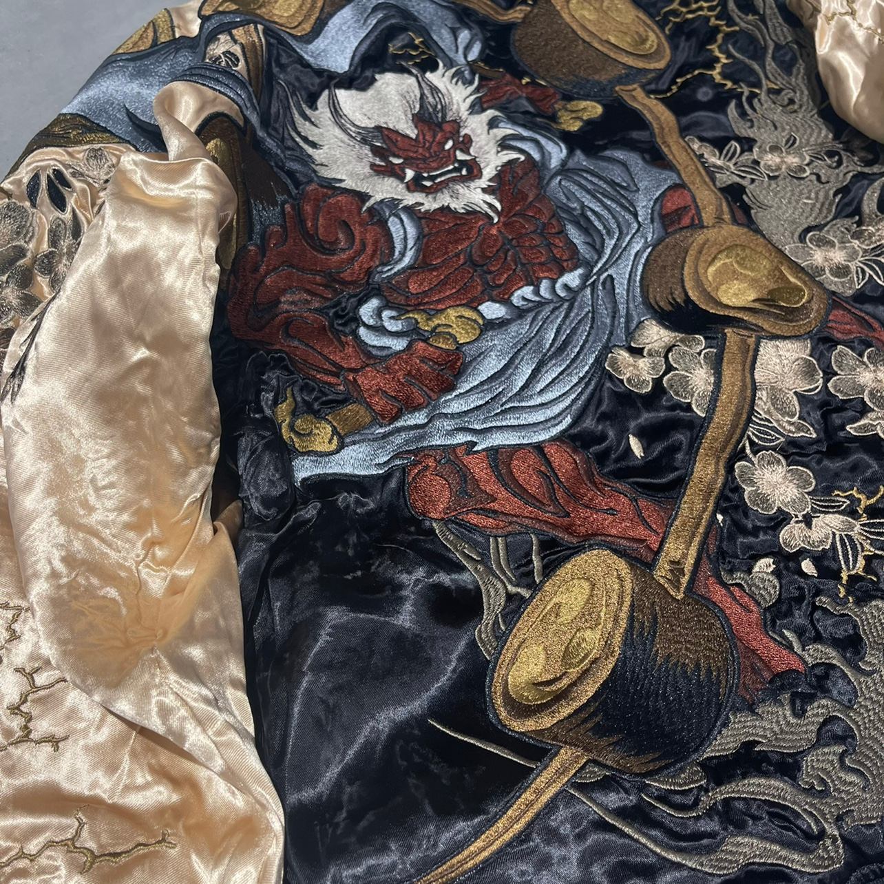 Embroidered Raijin torso with flowing sash and petals on the sukajan jacket.