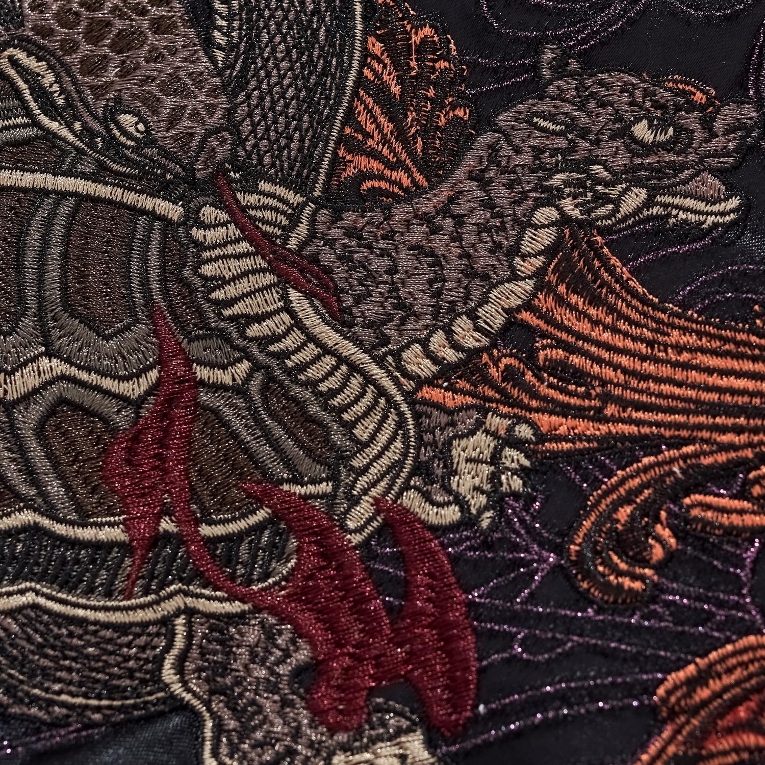 Macro shot of the Black Tortoise (Genbu) showing the intricate stitching of the snake scales and tortoise shell.