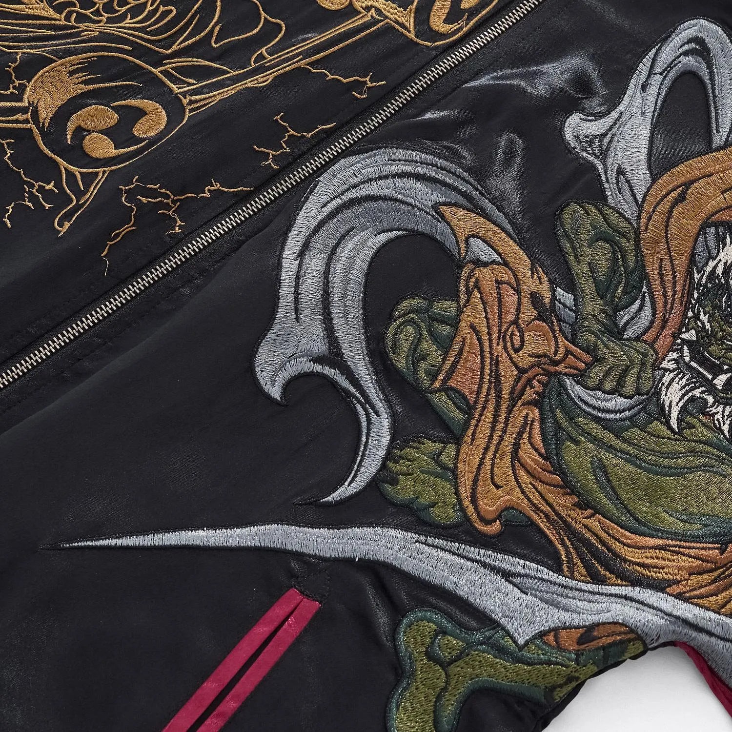 Detailed embroidery shot of the Thunder God's green robes and storm drums.