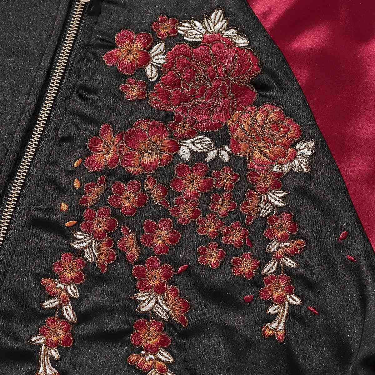 Chest detail—peony cascade embroidery beside the zipper.