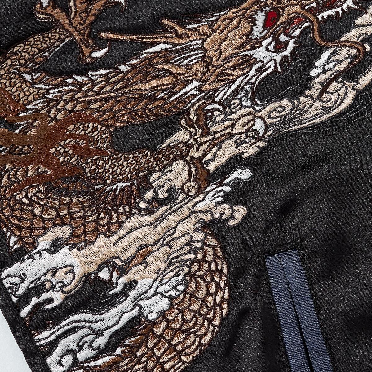 Close-up of dragon body embroidery with layered scales and swirling clouds