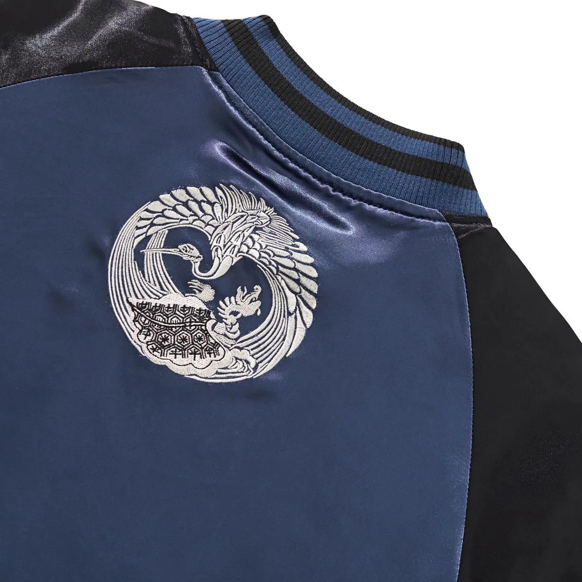 Close-up embroidery detail of the silver Crane crest.