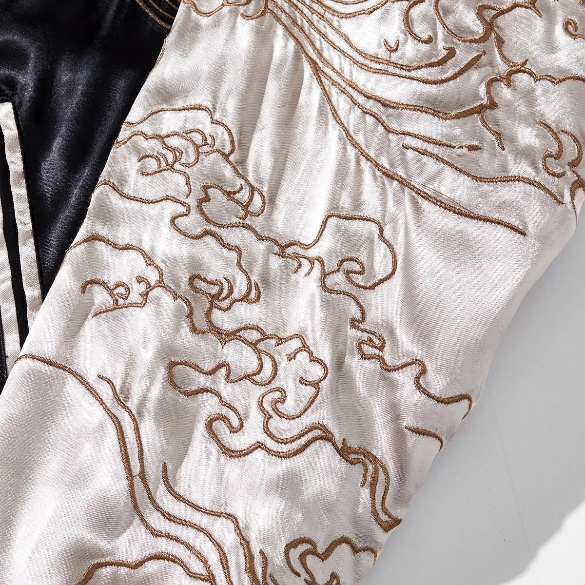 Close-up of intricate Ukiyo-e ocean wave embroidery on the satin sleeve.
