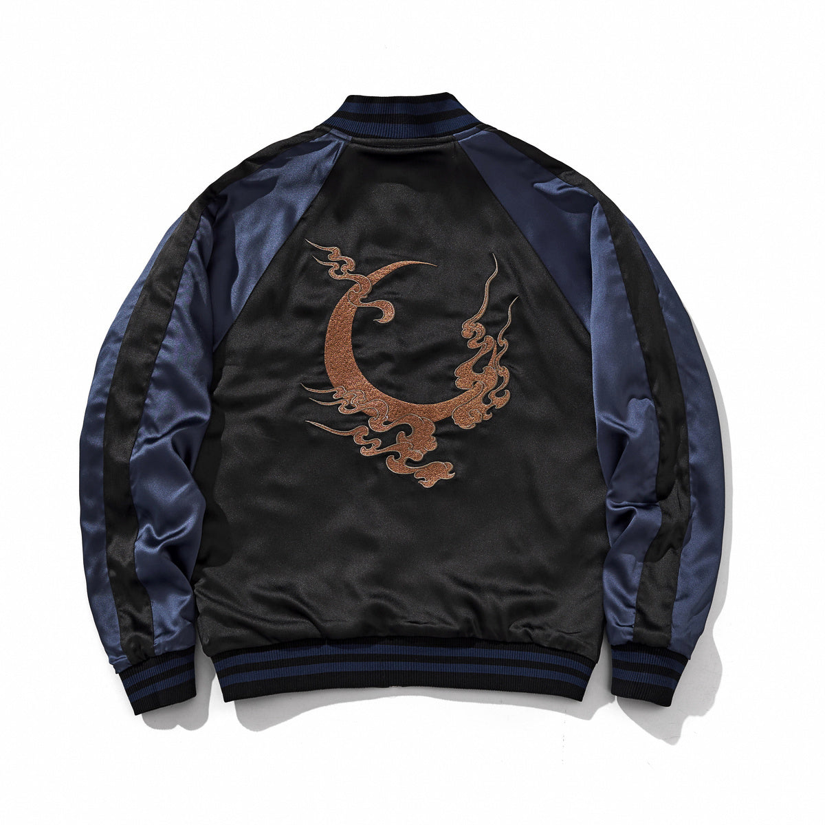 Centered bronze crescent-and-cloud emblem on a reversible sukajan jacket, back view, side B, navy.