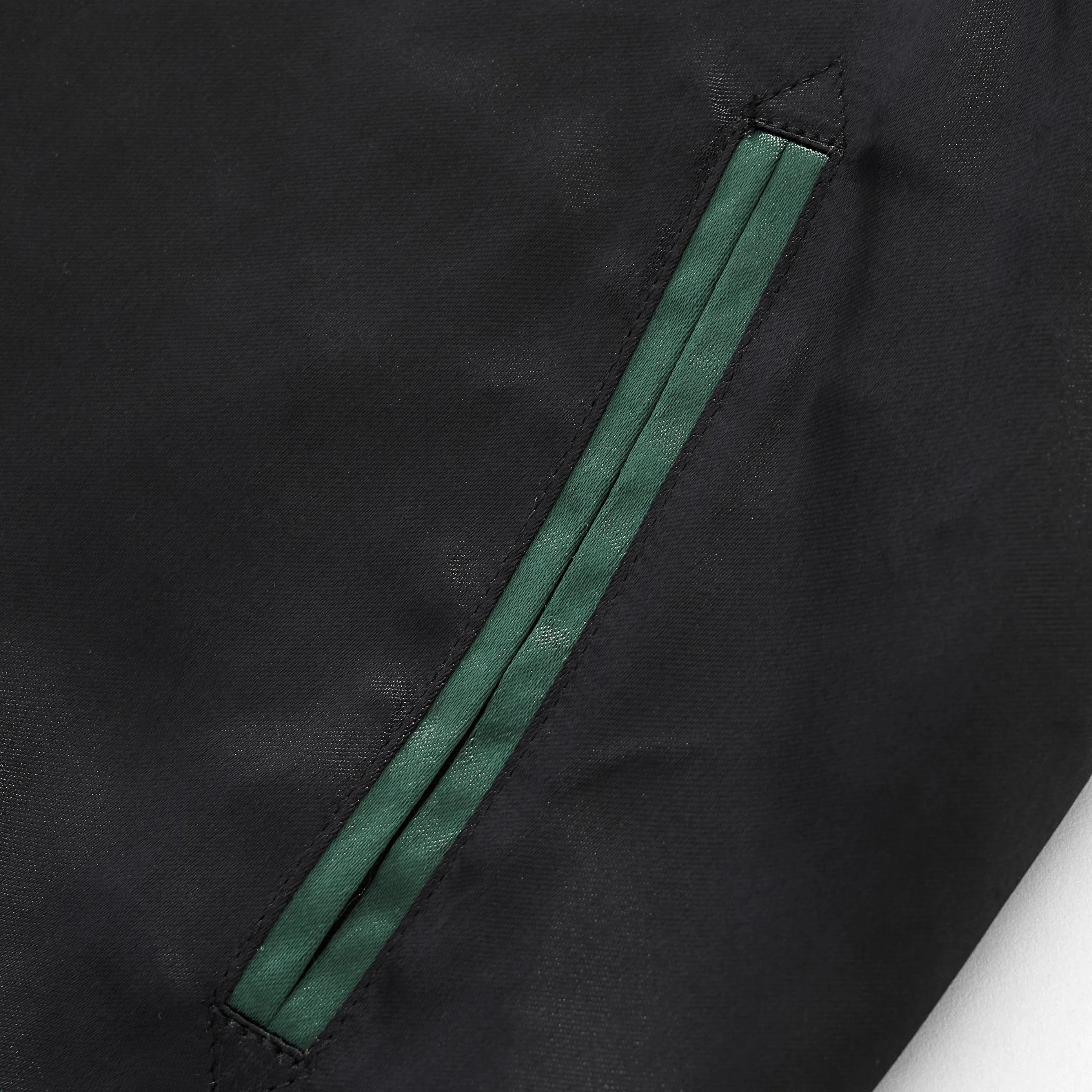 Reinforced side welt pocket detail with green trim.