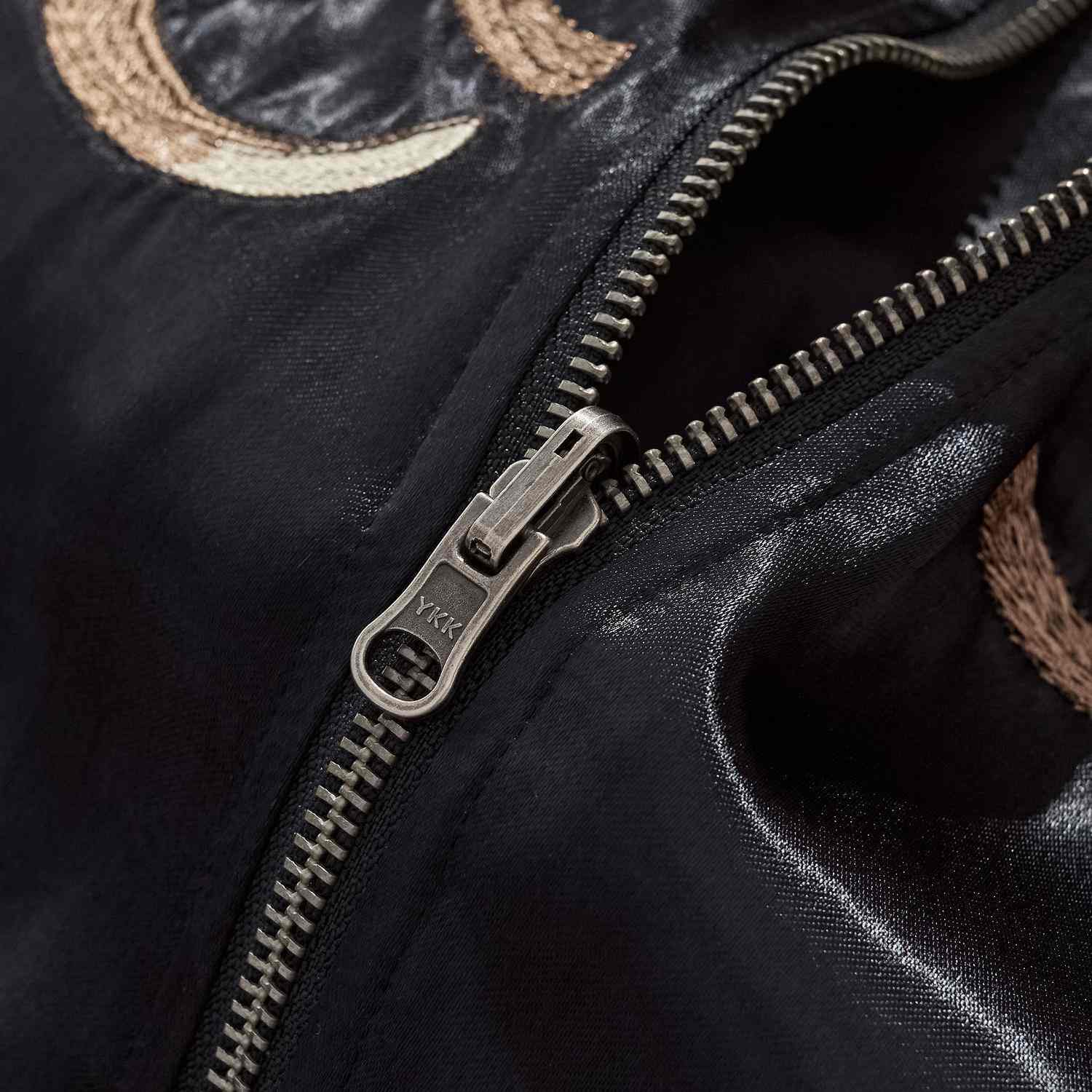 Close-up of durable YKK metal zipper with smooth satin body.