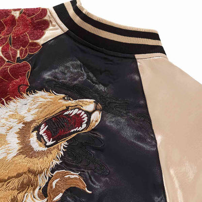 Collar detail — Beige sleeve joins black body; roaring lion embroidery with striped rib.