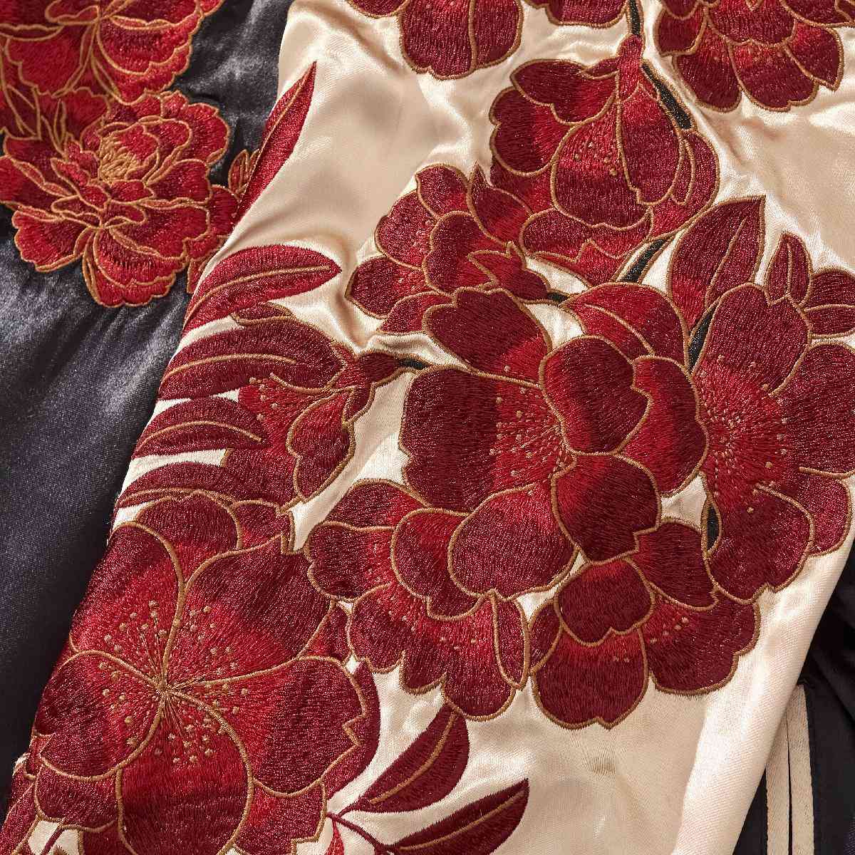 Close-up — white sleeve with layered red peony embroidery and gold outlines