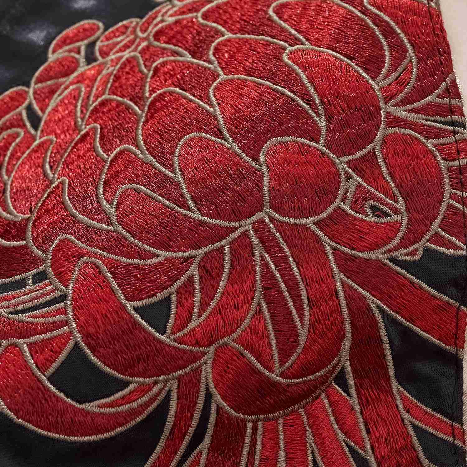 Layered chrysanthemum petals in raised satin stitch.