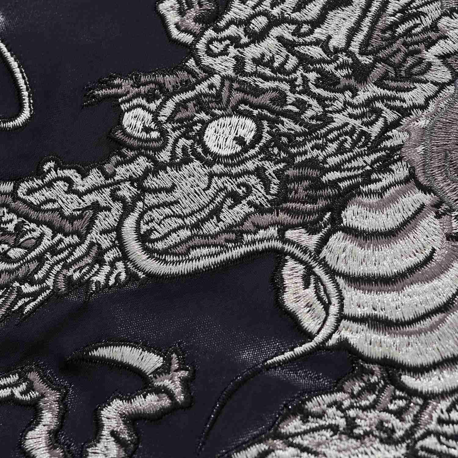 Dragon eye and snout embroidery macro showing dense stitching.
