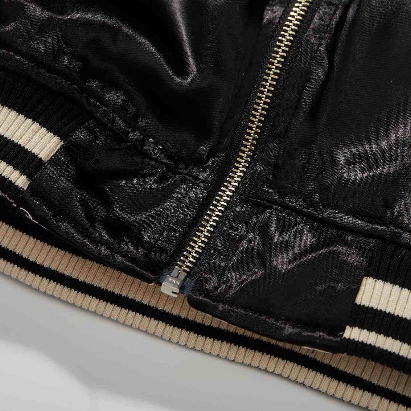 Hem/zip detail — bottom stop with reinforcement stitching.