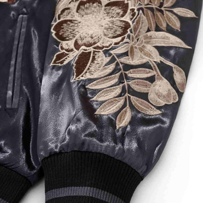 Sleeve cuff detail — peony-and-leaf embroidery with rib knit cuff.