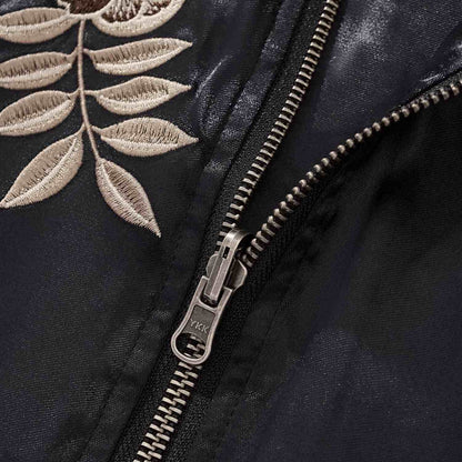YKK zipper close-up with leaf embroidery.