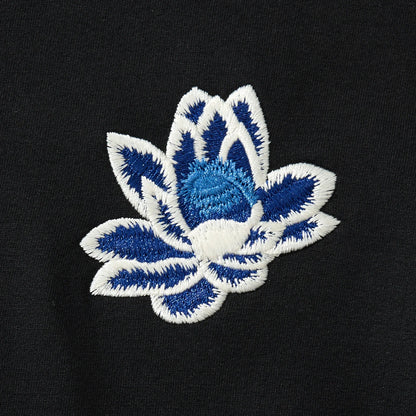 Chest lotus embroidery close-up on the black hoodie with clean edges