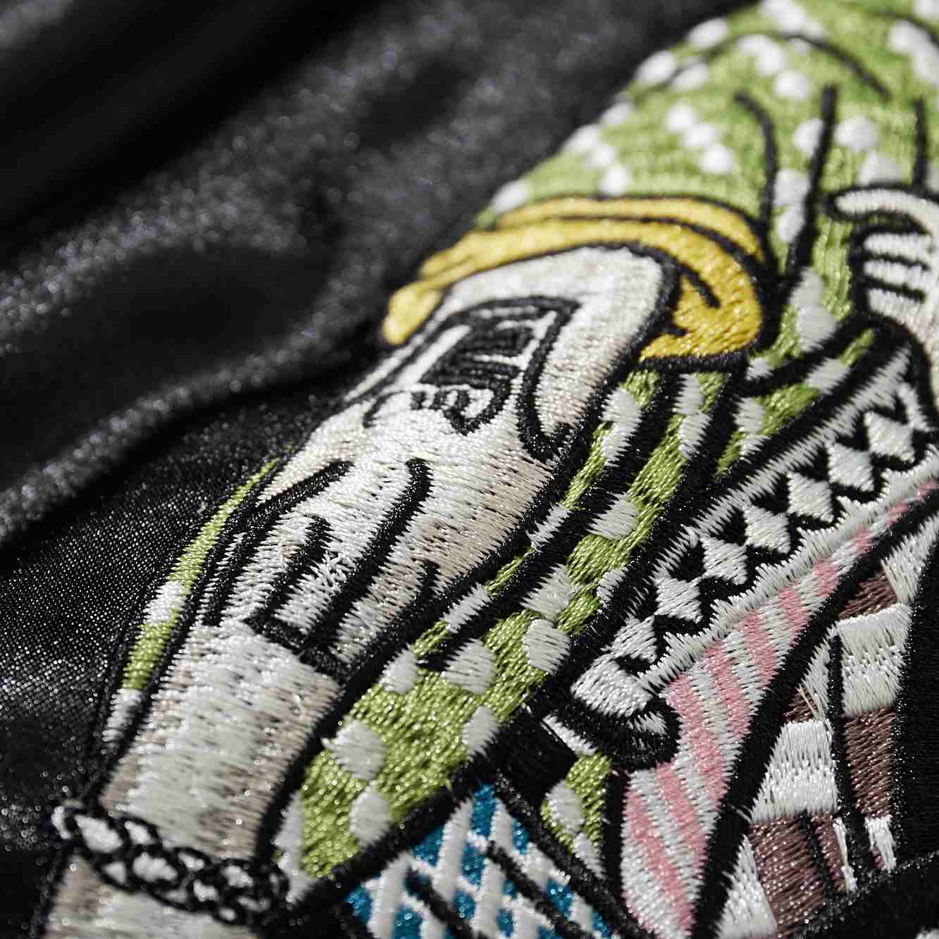 Close-up of green fighter’s Kanji Housen patterned sleeve embroidery on Crows Suzuran vs Housen rivalry sukajan jacket.