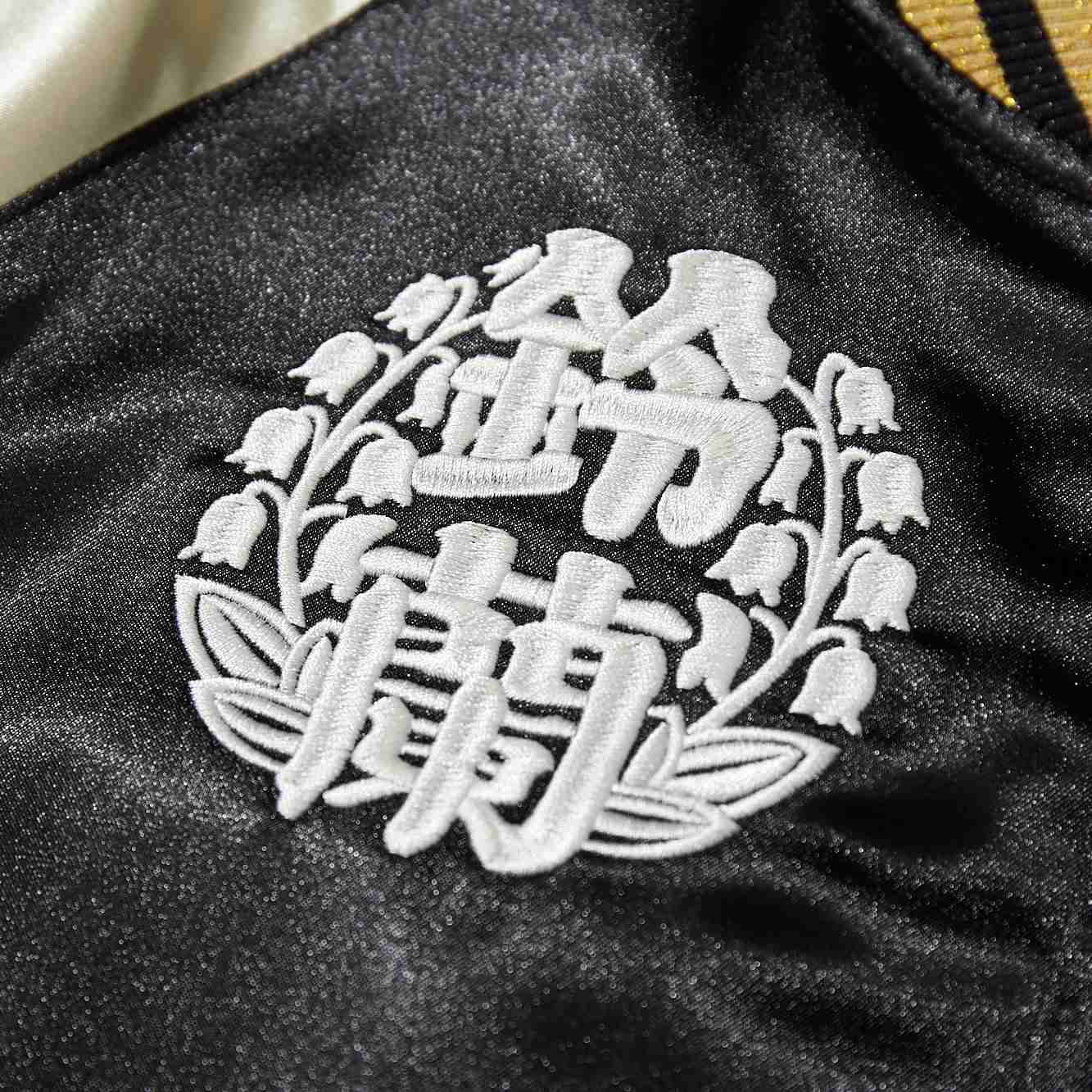 Close-up of kanji Suzuran high school crest embroidery on black satin Crows Suzuran vs Housen sukajan jacket.