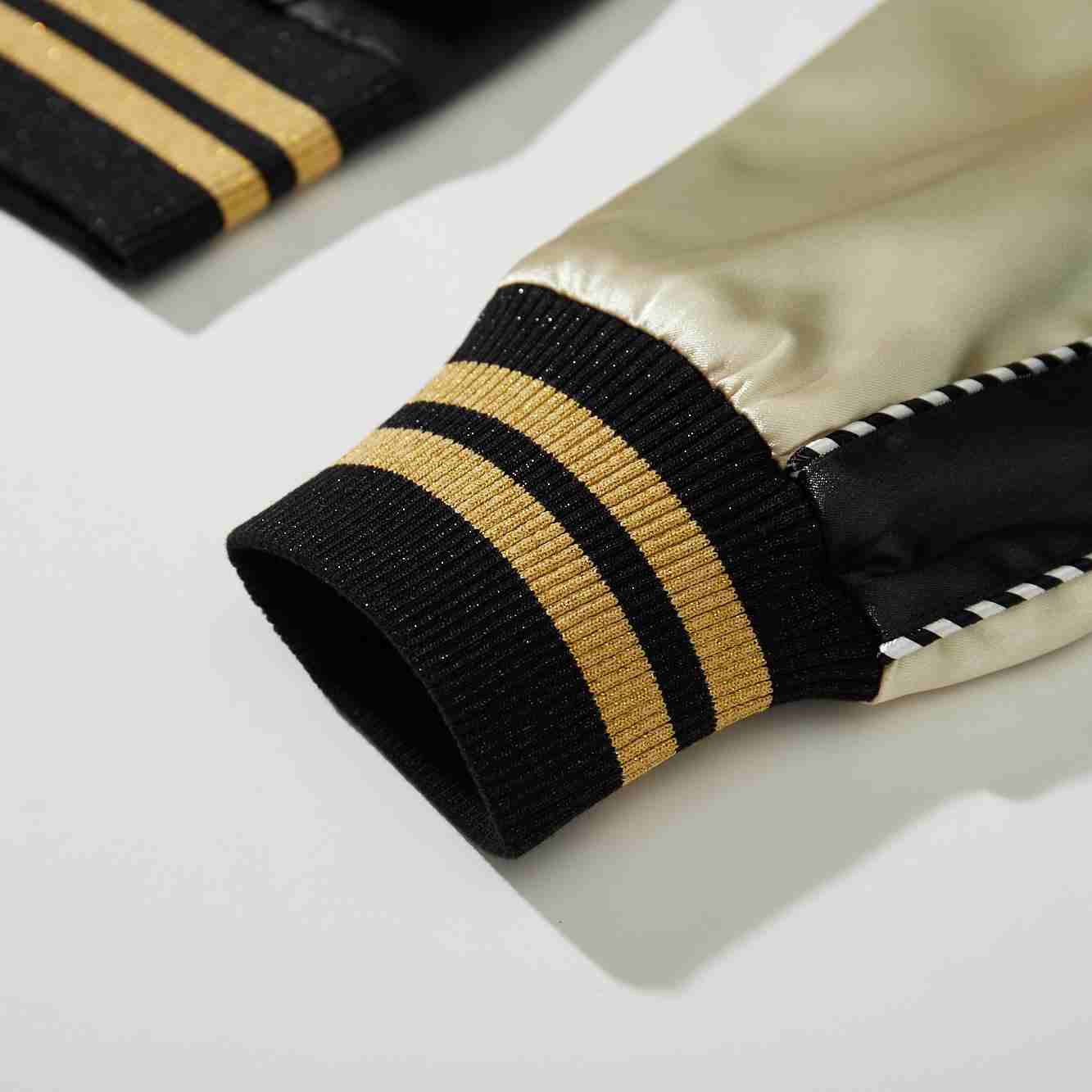 Detail of beige sleeve and black ribbed cuff with gold stripes on Crows Suzuran vs Housen rivalry sukajan jacket.