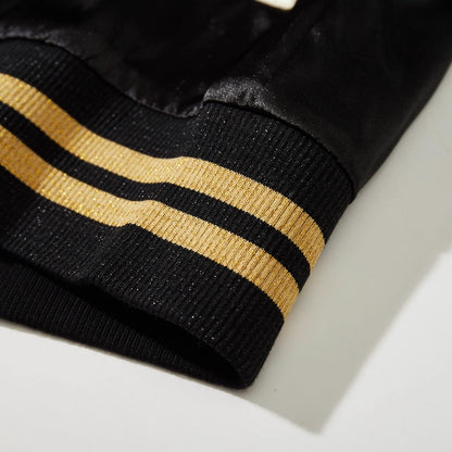 Detail of solid black ribbed hem and satin body on Dragon Ball Rider anime sukajan jacket.