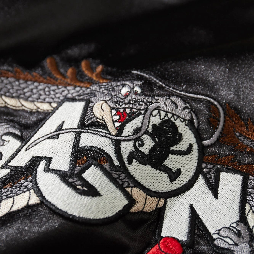Macro detail of coiled dragon biting circular logo embroidery on Dragon Ball Rider Dragon Ball sukajan.
