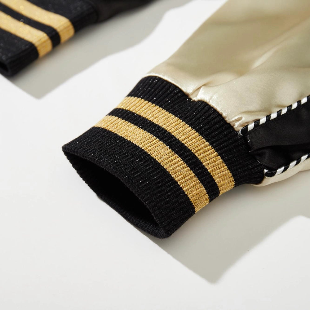 Ribbed cuff detail with gold and black stripes on beige sleeve of Dragon Ball Rider embroidered sukajan.