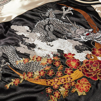 Close-up of embroidered dragon with clouds, crescent arc, and peony flowers.