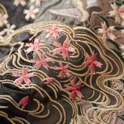 Close-up of sakura blossoms and wave embroidery on a black sukajan