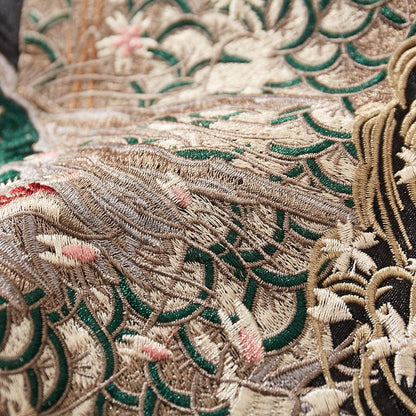 Close-up of layered dragon scales embroidery with sakura petals on a black sukajan