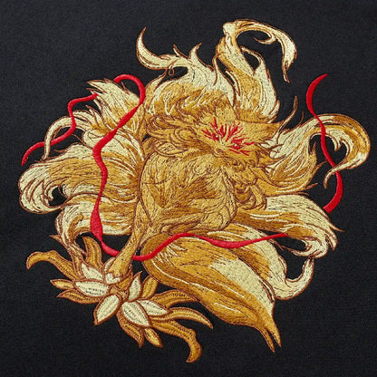 Close up of large golden nine-tailed fox and lotus embroidery on back of black sweatshirt