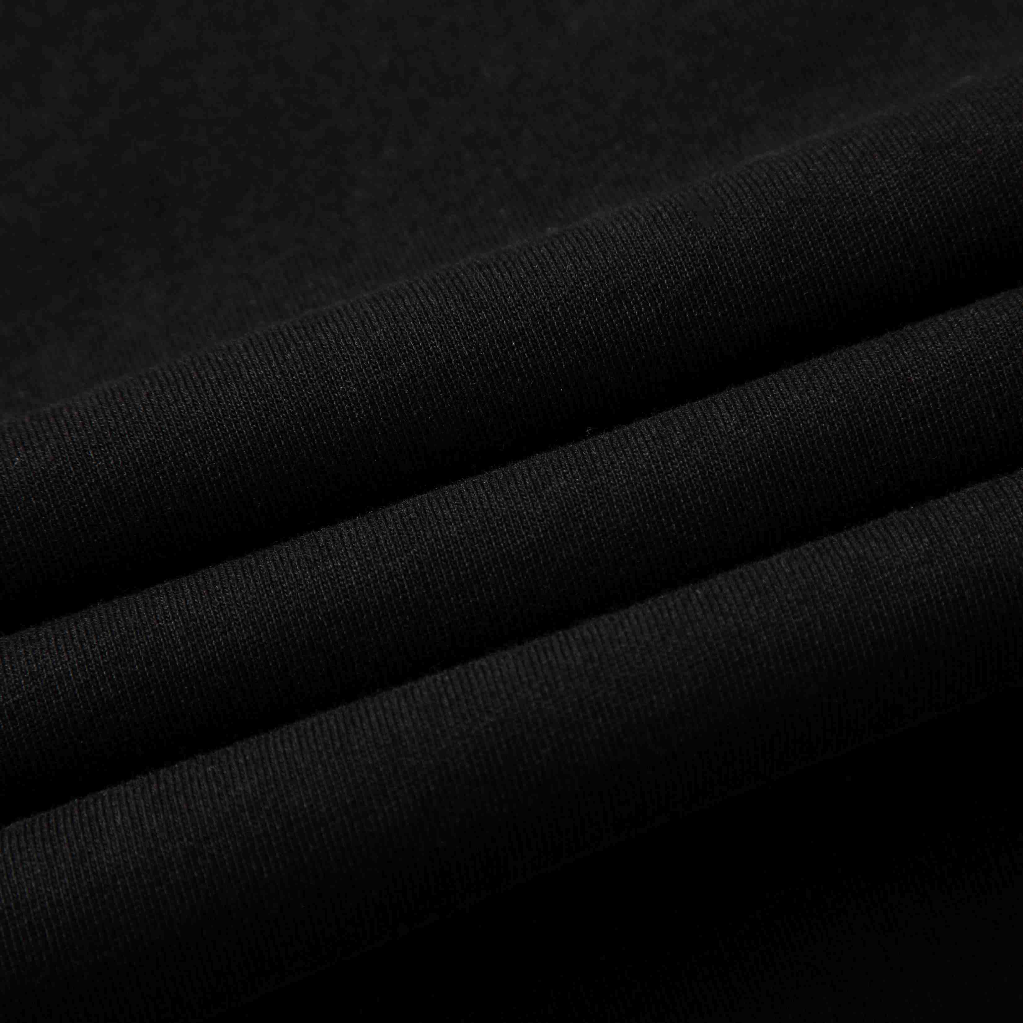 Black cotton jersey fabric folded—smooth handfeel and fine knit texture