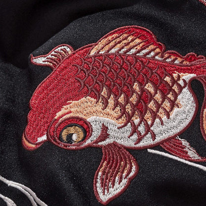 Macro embroidery of a goldfish showing layered scales and crisp stitching
