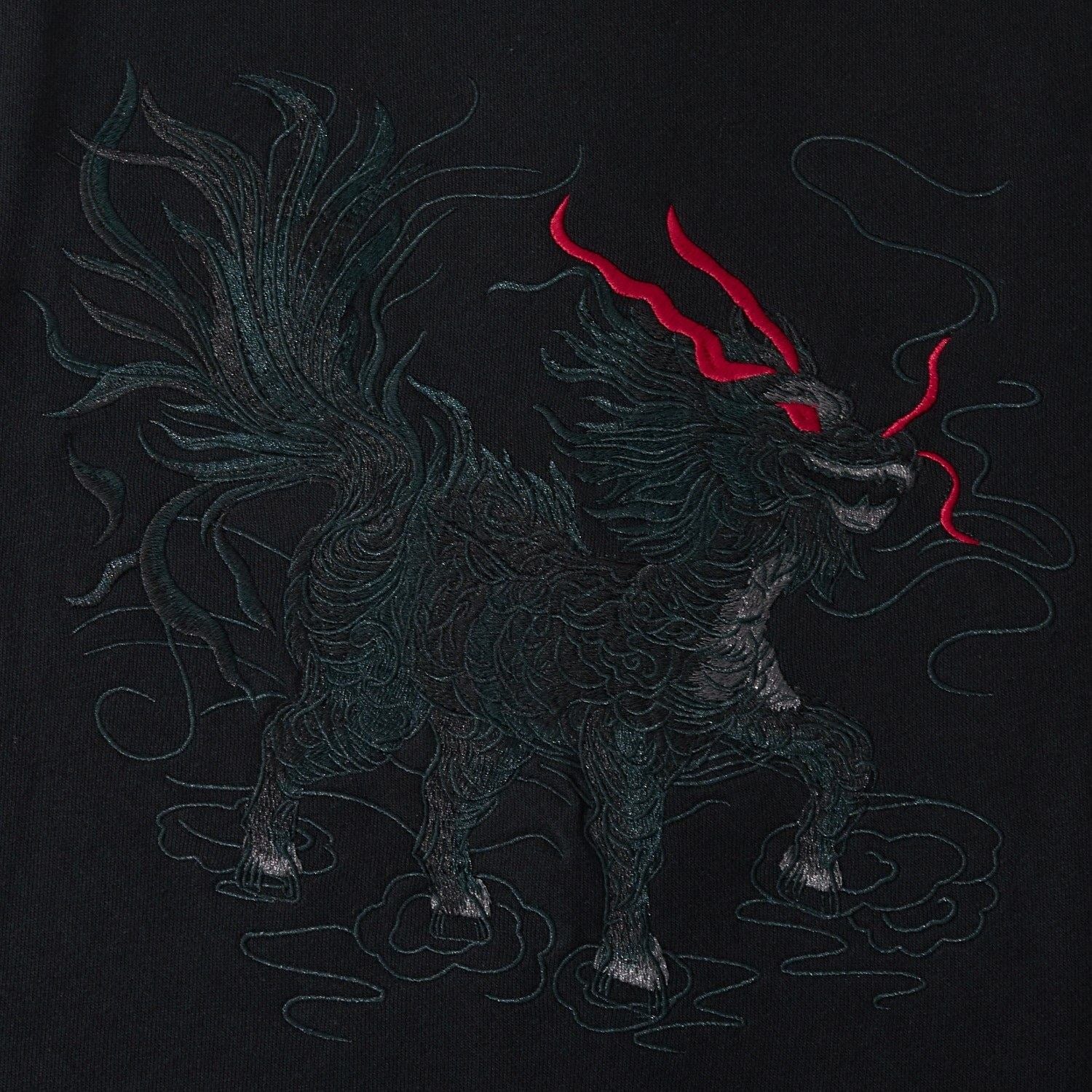 Close-up of Kirin embroidery on the black sweatshirt with layered, textured threadwork